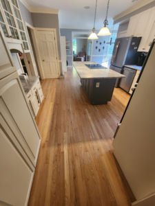 A modern kitchen with newly installed light hardwood floors by floorzone.inc in Los Angeles, CA.
