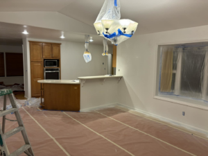A kitchen and living area prepared for painting, showcasing services from Considerate Repair in Walla Walla, WA.