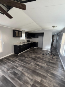 A newly renovated kitchen and living area featuring dark cabinets, new countertops, and modern flooring by Hard Knox Handyman in Knoxville, TN.