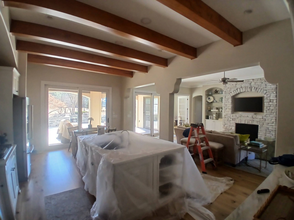 Kitchen and living room prepared for painting or renovation with protective coverings by Southeastern Painting & Drywall in Wilmington, NC
