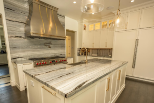 A luxurious kitchen featuring a large marble or granite island and matching backsplash by Accent Marble & Granite, Inc in Phoenix, AZ