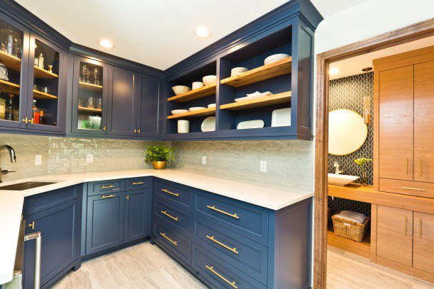A kitchen and pantry area featuring blue cabinets and open shelving by Kornerstone Kitchens in Orlando, FL.