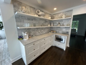 A well-organized kitchen pantry with white cabinets, floating shelves, and a marble backsplash, installed by Safe Haven Home Services in Nashville, TN.