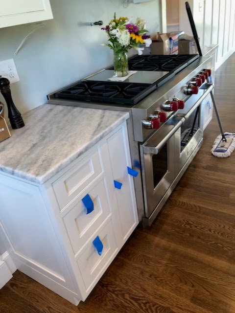 Kitchen range area with new white cabinets and a grey veined countertop by Centennial Granite in New Haven, CT.