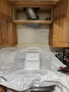 Kitchen area with a range hood removed, showing exposed ductwork and electrical outlets during a remodel by Peraza Handyman Services Llc in Bakersfield, CA.
