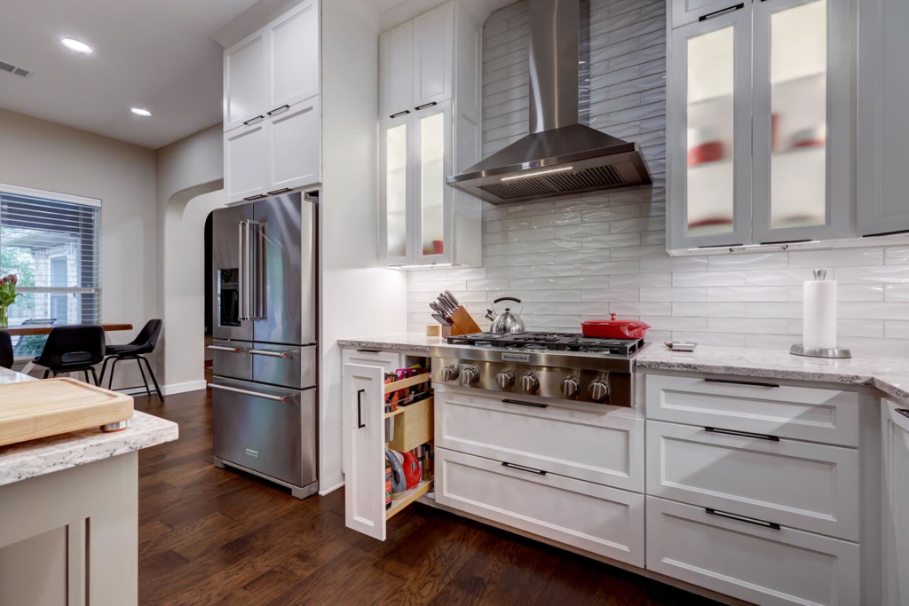 Stainless steel refrigerator and professional range in a kitchen renovation by Adams Company in Cedar Park, TX