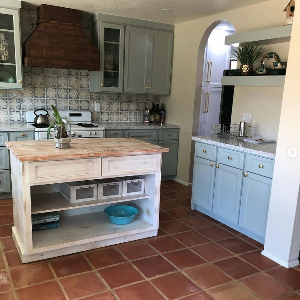 A kitchen remodel featuring blue cabinets, a rustic wood island, and terracotta-style flooring by A&R Home Improvements in El Paso, TX