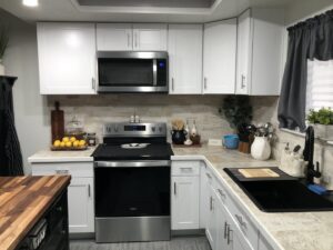 A completed modern kitchen remodel with white cabinets and new appliances by Peak Handyman Services in Las Vegas, NV.