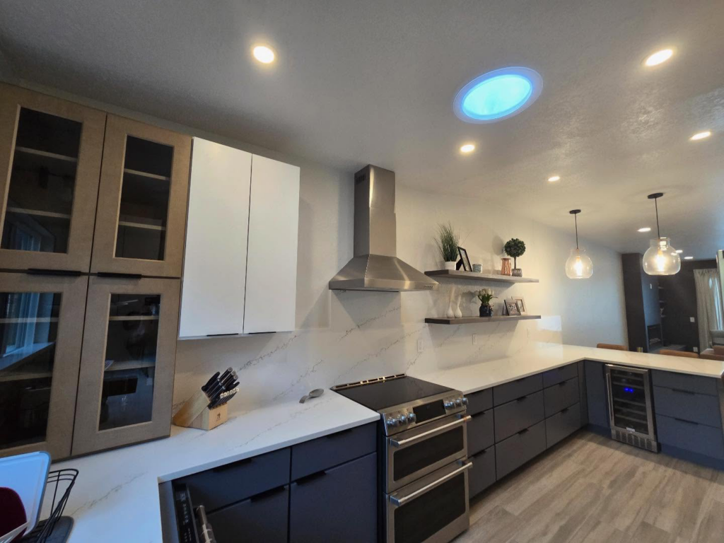 A modern kitchen remodel featuring new cabinets, stainless steel appliances, and a range hood by Raven Construction LLC in Tucson, AZ.