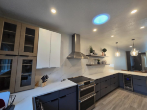 A modern kitchen remodel featuring new cabinets, stainless steel appliances, and a range hood by Raven Construction LLC in Tucson, AZ.