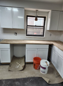 A kitchen undergoing remodeling with new white cabinets and wooden countertops by I.B. Remodeling LLC in Dayton, OH.
