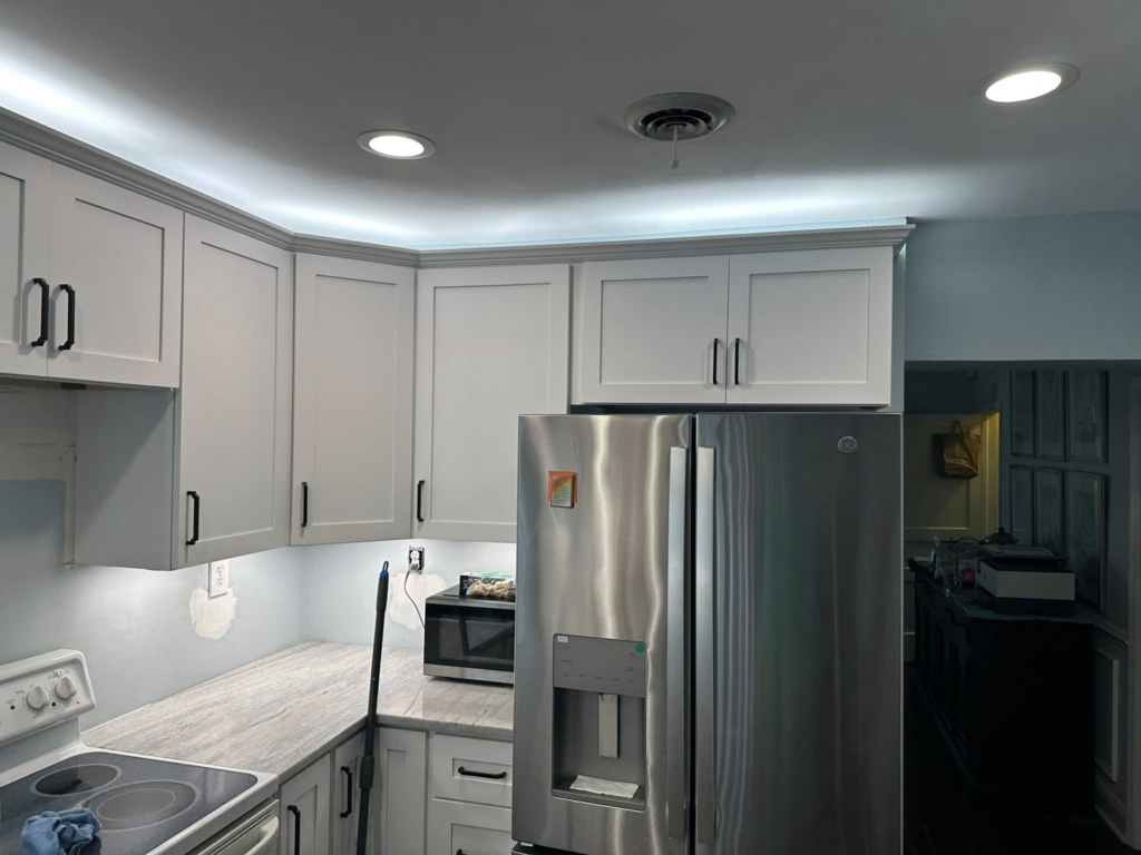 A kitchen remodel featuring new cabinets, lighting, and refrigerator by W. Brian Roberts Construction in Wilmington, NC