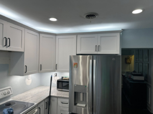 A kitchen remodel featuring new cabinets, lighting, and refrigerator by W. Brian Roberts Construction in Wilmington, NC