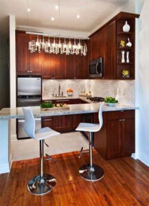 A kitchen remodel featuring dark wood cabinets, a small island, and a chandelier by Chicago Service Source Inc in Chicago, IL