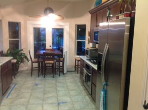 A kitchen remodel in progress with blue tape on the tile floor by All Star Construction, Inc. in Houston, TX.