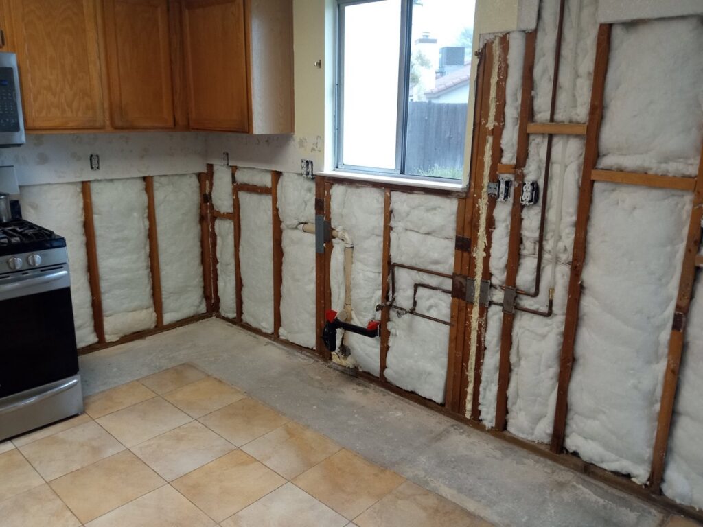 Kitchen remodel in progress showing exposed walls, insulation, and plumbing by Cal Heights Construction And Handyman Services in Bakersfield, CA
