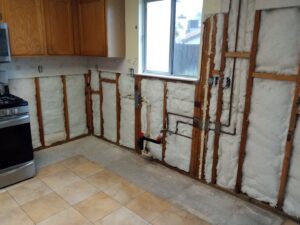 Kitchen remodel in progress showing exposed walls, insulation, and plumbing by Cal Heights Construction And Handyman Services in Bakersfield, CA