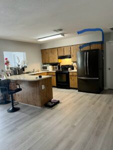 A kitchen with light wood cabinets and black appliances, showing a remodel in progress by Desert Remodel in Scottsdale, AZ.
