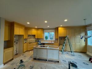 A kitchen remodel in progress with new cabinets, a ladder, and tools on the floor by Restore Renew Remodel in Portland, OR.