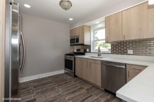 A modern kitchen remodel with light wood cabinets and stainless steel appliances by Grizzly Renovations in Naperville, IL