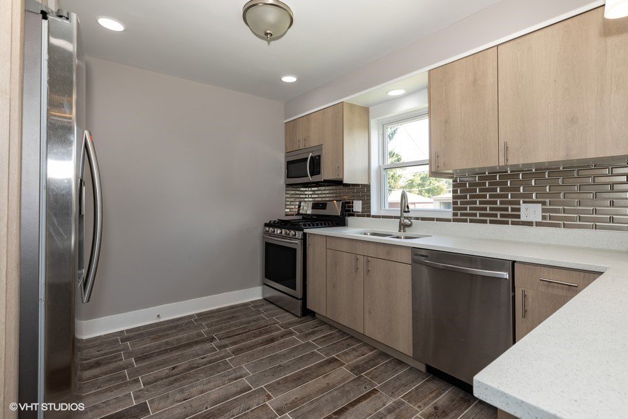 A modern kitchen remodel with light wood cabinets and stainless steel appliances by Grizzly Renovations in Naperville, IL