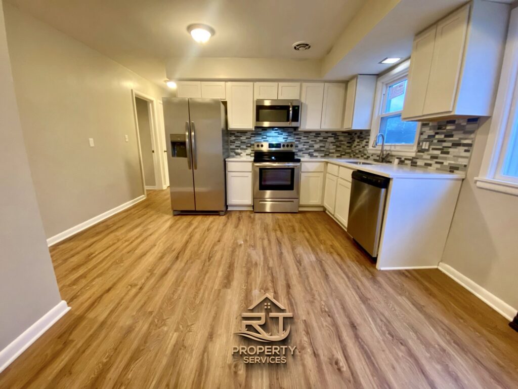 A modern kitchen remodel featuring new white cabinets, stainless steel appliances, and a tiled backsplash by RT Property Services in Allendale, MI