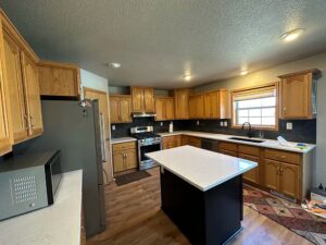 A recently completed kitchen remodel featuring new countertops and a central island by Vander Wal Contracting, LLC in Bismarck, ND