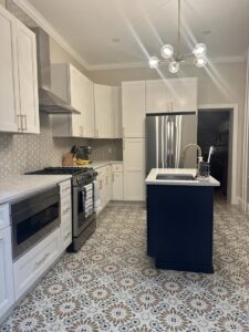 Kitchen remodel with white cabinets, a navy island, and decorative patterned floor tiles by Corkery Customs & Remodeling LLC in Philadelphia, PA
