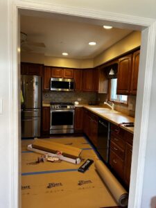 A kitchen in the early stages of a remodel, with floor protection and new material boxes, managed by Keeler Construction Group Inc. in Blue Island, IL.