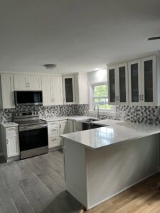 Kitchen remodel with new white cabinets, hexagonal tile backsplash, and island by CWS Handyman LLC in Seekonk, MA