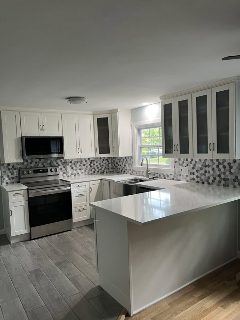 Kitchen remodel with new white cabinets, hexagonal tile backsplash, and island by CWS Handyman LLC in Seekonk, MA