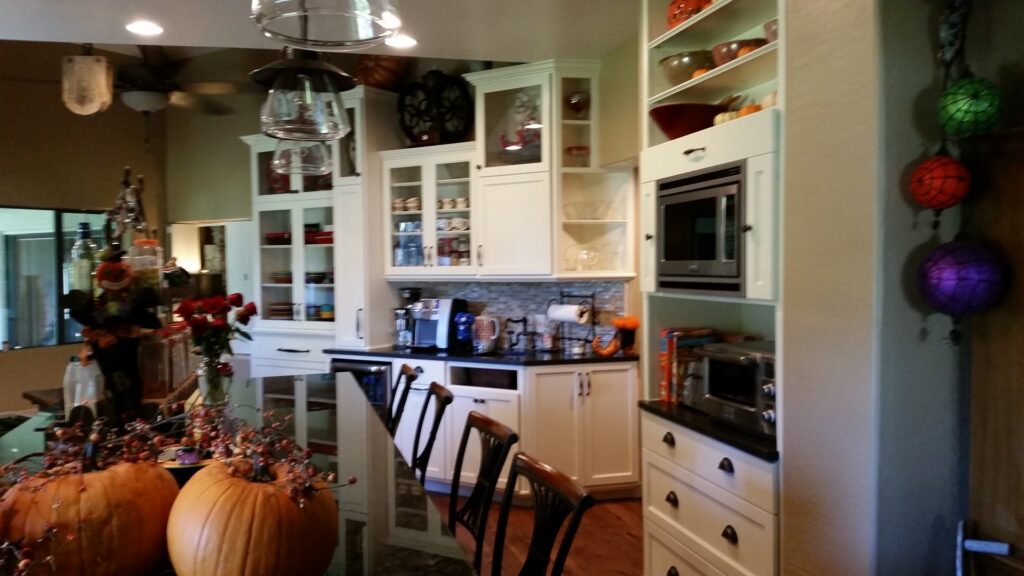 A completed kitchen remodel with white cabinets and black countertops by Celano Construction in Mesa, AZ