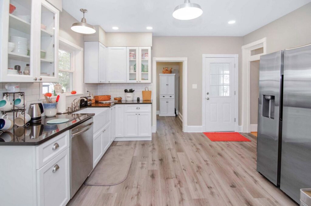 A kitchen remodel featuring white cabinets, black countertops, and stainless steel appliances by Total Craftsmen in Towson, MD