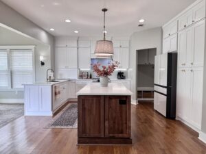 Kitchen remodel with white cabinets and a contrasting dark wood island by Prestige Remodeling Solutions in Jackson, TN.