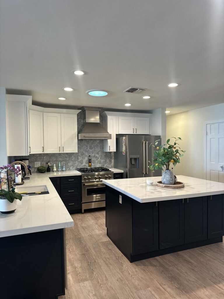 A recently completed kitchen remodel with white upper and dark lower cabinets, and a large island by Integrity Contracting in Cleveland, OH