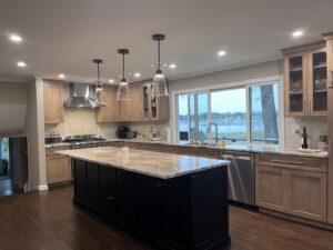 Beautifully remodeled kitchen featuring a large island, wood cabinetry, and recessed lighting by Byrd's Contracting, LLC in Bristol, CT.
