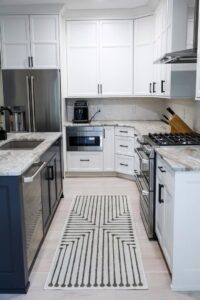 A renovated kitchen with white cabinets, stainless steel appliances, and a central island by Kore Construction LLC in Cincinnati, OH.