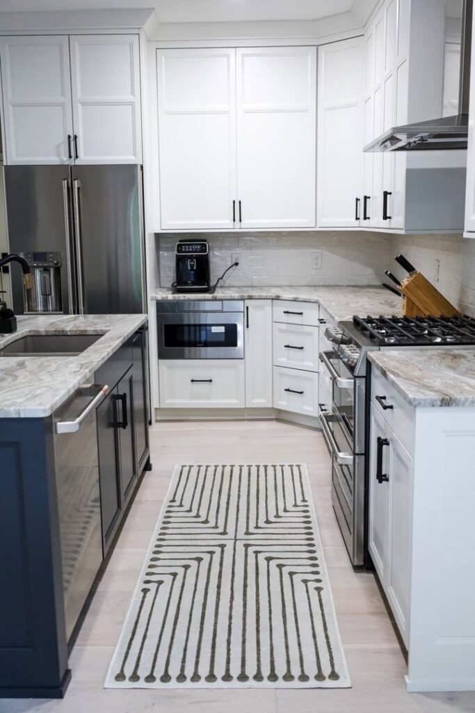 A renovated kitchen with white cabinets, stainless steel appliances, and a central island by Kore Construction LLC in Cincinnati, OH.