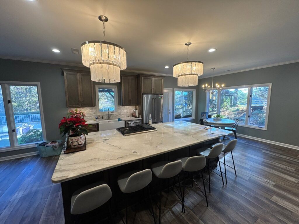 A kitchen remodel featuring a large central island and modern light fixtures by CMT Construction LLC in Columbia, MO.