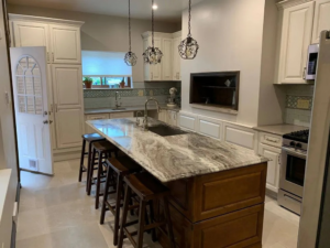 A beautifully renovated kitchen featuring a large island with a marble countertop, by McIntyre's Renovations LLC in Pittsburgh, PA