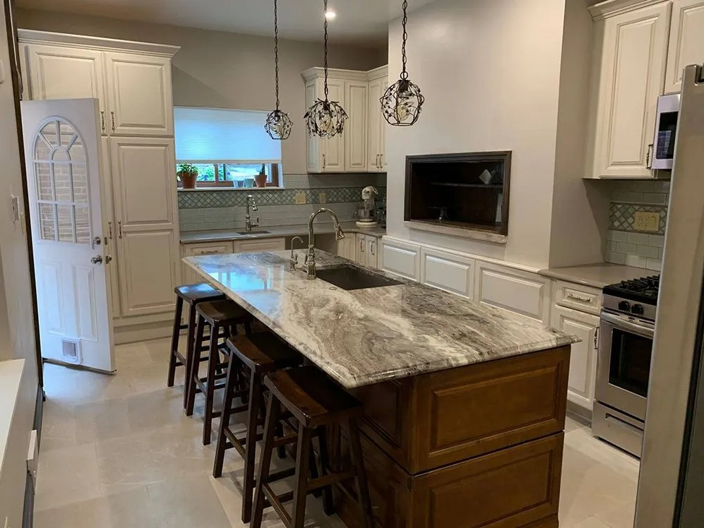 A beautifully renovated kitchen featuring a large island with a marble countertop, by McIntyre's Renovations LLC in Pittsburgh, PA