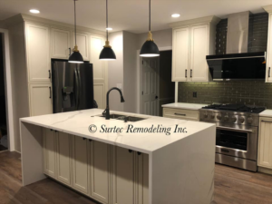 Spacious kitchen remodel with a large island, modern refrigerator, and pendant lighting by Surtec Remodeling Inc. in Pittsburgh, PA.