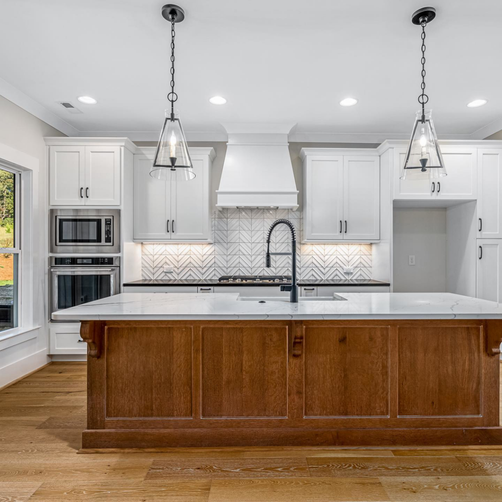 A renovated kitchen featuring white cabinets, a wood island, and new appliances installed by Mitchco, Inc. in Winston-Salem, NC.