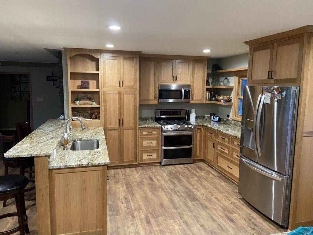 A spacious kitchen remodel with light wood cabinets, granite countertops, and stainless steel appliances by Inova Builds in Bloomington, MN.
