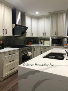 Remodeled kitchen showcasing new appliances, white cabinets, and a spacious island by Surtec Remodeling Inc. in Pittsburgh, PA.