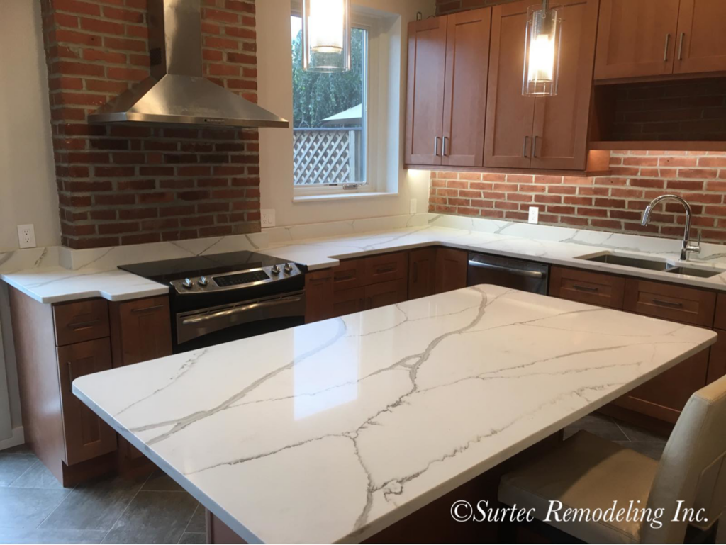 A beautifully remodeled kitchen featuring a brick backsplash and white quartz countertops by Surtec Remodeling Inc. in Pittsburgh, PA.