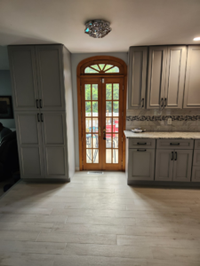 A renovated kitchen showcasing arched wooden double doors and a tall pantry cabinet by Zig's Home Improvements in Reading, PA.