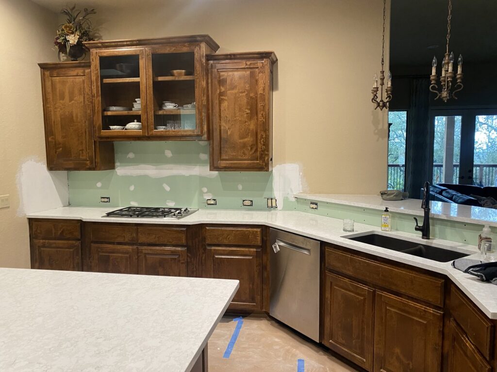 Kitchen renovation in progress with new countertops, cabinets, and exposed drywall for backsplash by Vargas Paint and Texture in San Antonio, TX.
