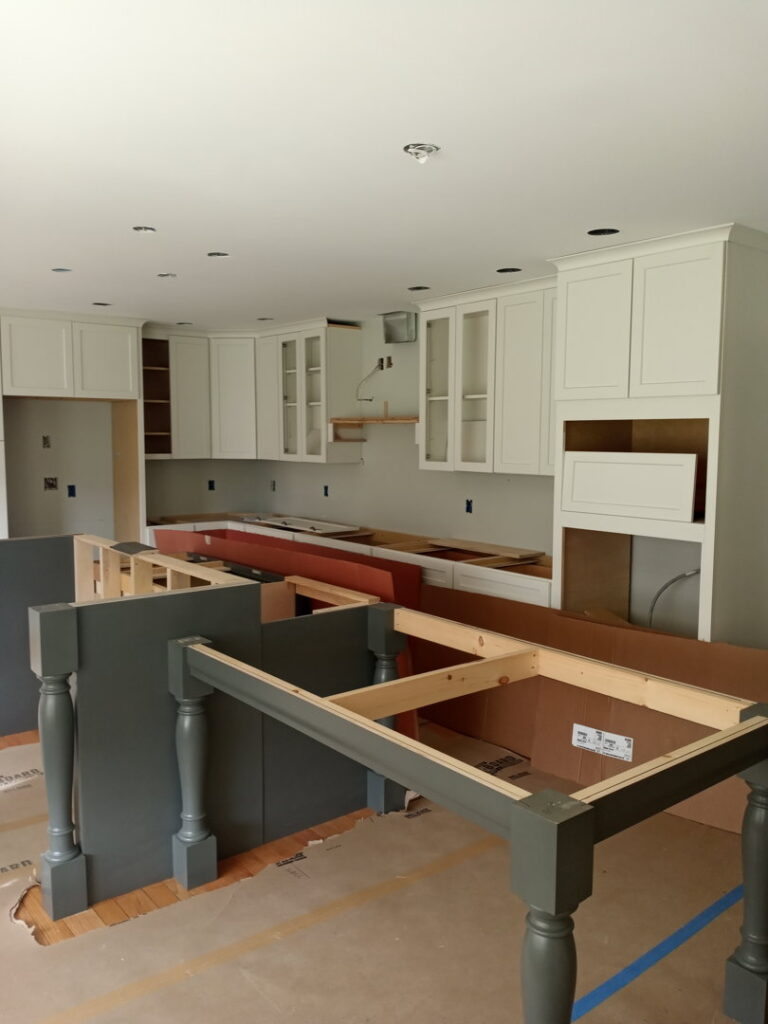 A kitchen renovation in progress, showing new white wall cabinets and base cabinet frames installed by McCollister Contracting LLC in New Castle, DE.