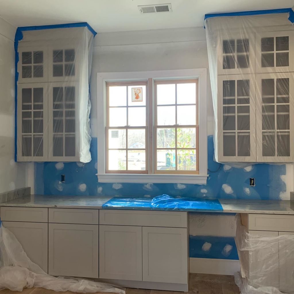Kitchen renovation in progress with installed cabinets, protected countertops, and walls prepped for painting by Mike Murphy Builders, LLC in Memphis, TN.